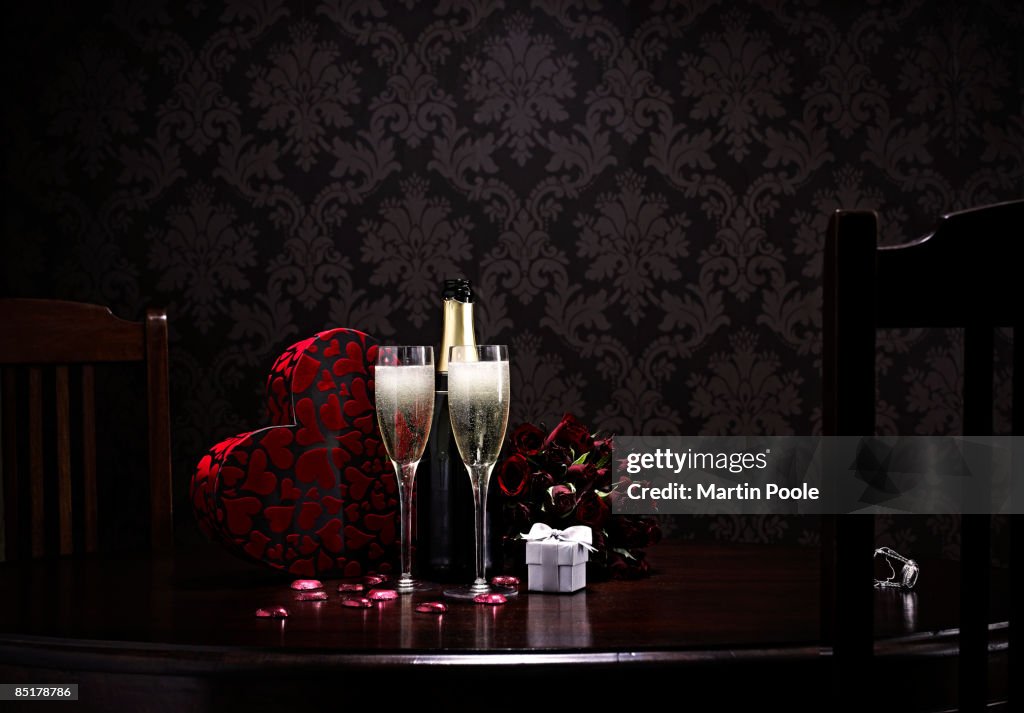 Champange and roses and choclates on table 