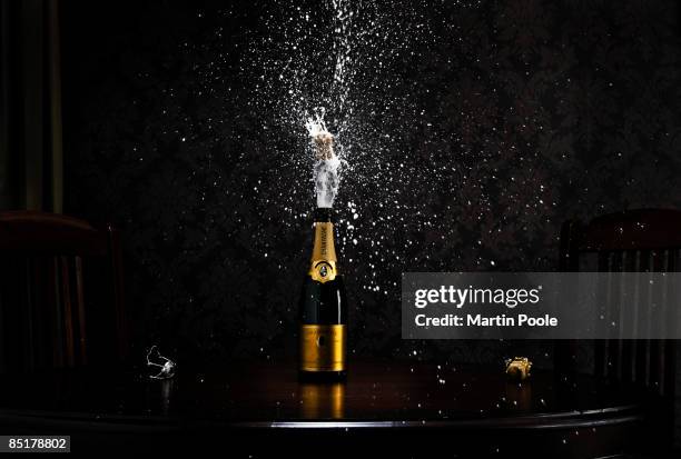 bottle of champange on table exploding cork - champagne fotografías e imágenes de stock