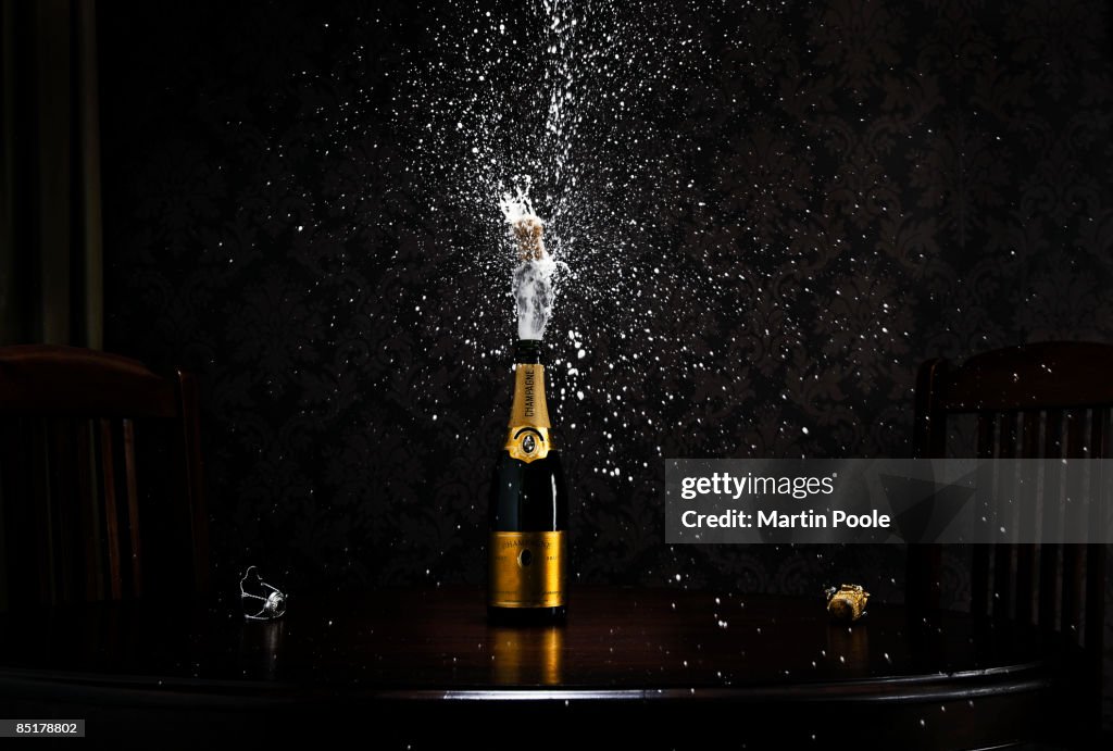 Bottle Of Champange On Table Exploding Cork Photo - Getty Images
