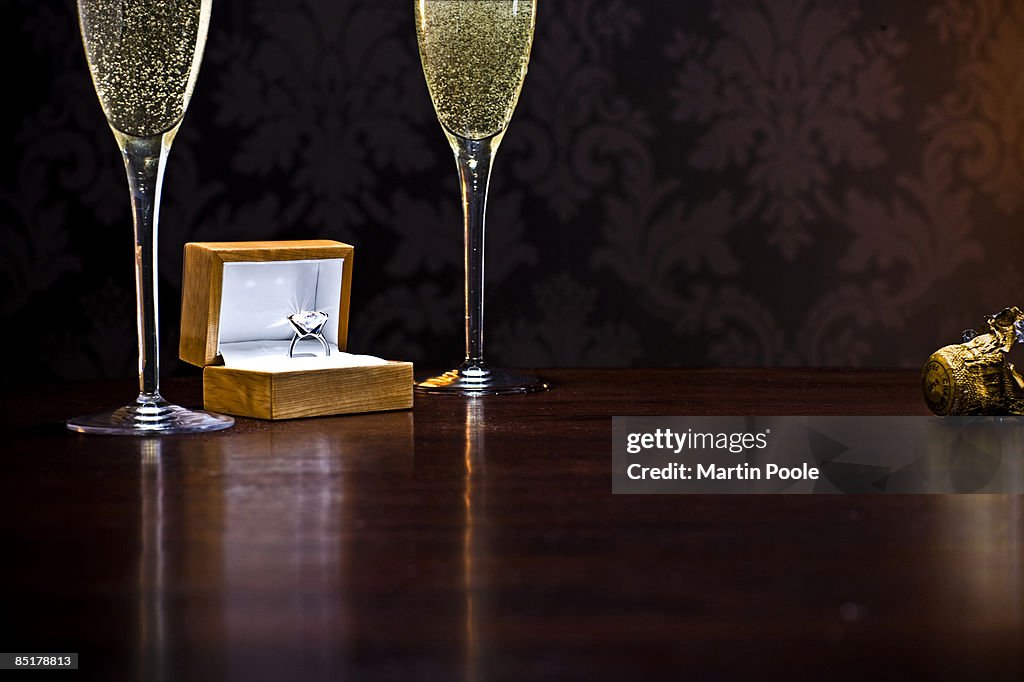 Diamond ring on table with champange glasses