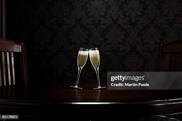 two champange glasses leaning to kiss on table - honour stock pictures, royalty-free photos & images