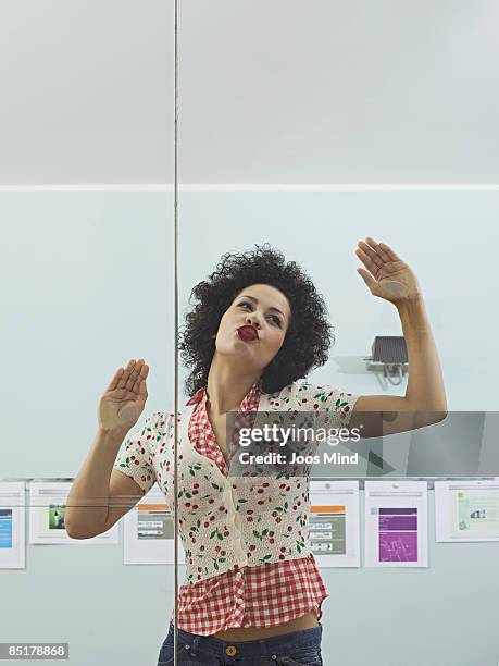 female office worker kissing on window glass - begehren stock-fotos und bilder