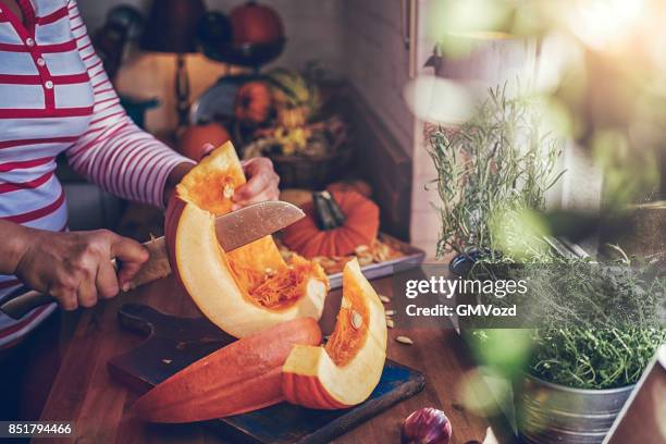 cutting fresh pumpkins for roasting in the oven - hokaido pumpkin stock pictures, royalty-free photos & images