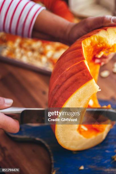 cutting fresh pumpkins for roasting in the oven - hokaido pumpkin stock pictures, royalty-free photos & images