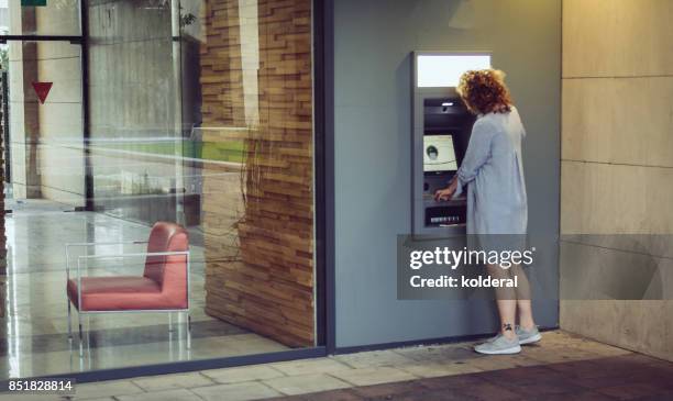 woman withdrawing cash from atm - israeli woman imagens e fotografias de stock