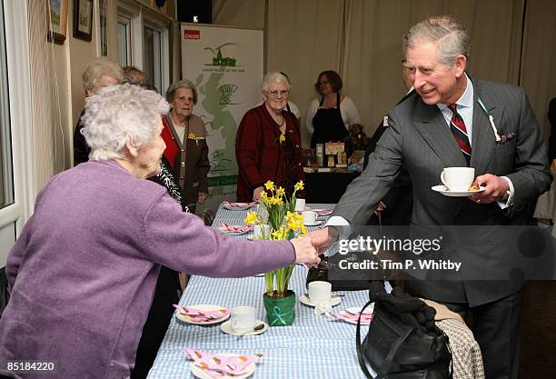 Prince Charles, Prince of Wales enjoys a cup of tea while meeting local people at the Froncysyllte Community Centre during his visit to Froncysyllte,...