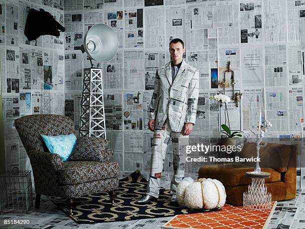 businessman dressed in newspaper suit - tarnung stock-fotos und bilder