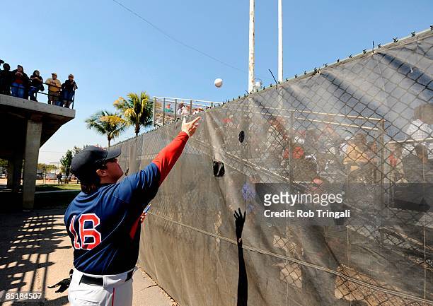Paul McAnulty of the Boston Red Sox throws back an autographed ball to a fan before a spring training game against the Baltimore Orioles at Fort...