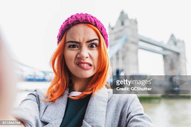 making funny faces for a selfie - funny face woman stock pictures, royalty-free photos & images