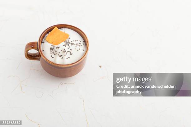 brown cup with whipped cream, chia seeds and dried mango. - mucilagem - fotografias e filmes do acervo