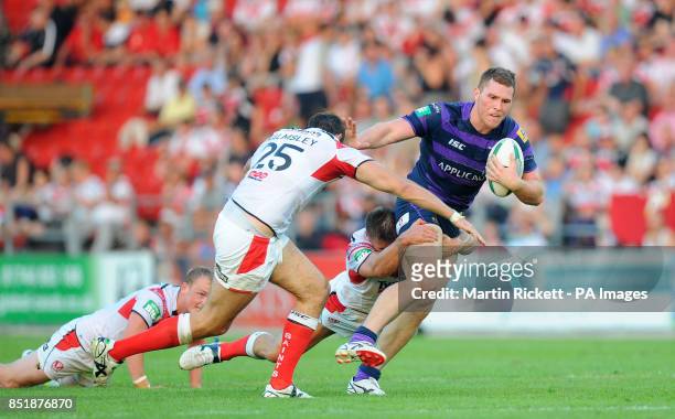 Wigan Warriors Dom Crosby is tackled by St Helens Alex Walmsley and Paul Clough during the Super League match at Langtree Park, St Helens.