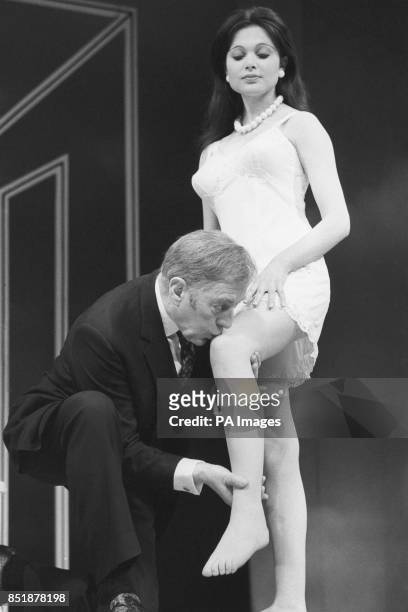 Sir Alec Guinness kisses the knee of Madeline Smith during a rehearsal of Alan Bennett's Habeas Corpus at the Lyric Theatre.