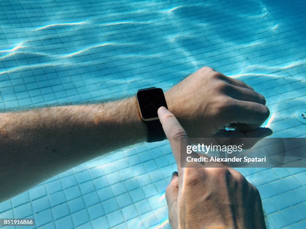 using smart watch in the swimming pool underwater - mens wrist watch stock-fotos und bilder