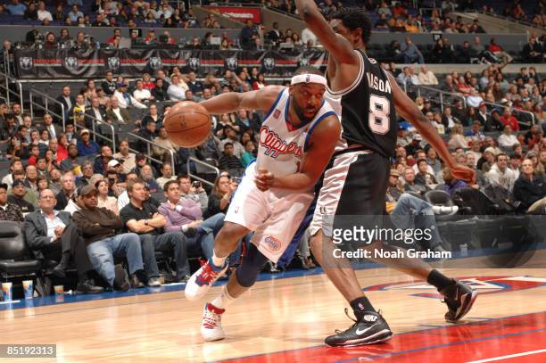 Baron Davis of the Los Angeles Clippers drives against Roger Mason of the San Antonio Spurs at Staples Center on March 2, 2009 in Los Angeles,...