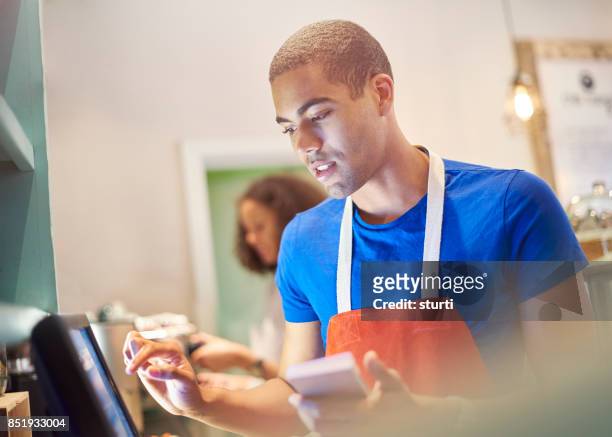 coffeeshop werknemer met digitale bestelling scherm - deeltijdbaan stockfoto's en -beelden