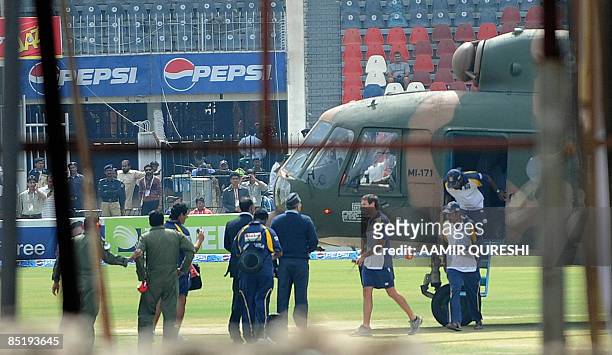 Sri Lankan cricket team members disembark from a Pakistani military helicopter onto the playing surface at The National Stadium in Lahore on March 3,...