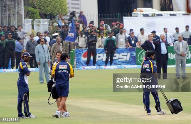 Sri Lankan cricket team members wait for a Pakistani military helicopter before their departure from the playing surface at The National Stadium in...