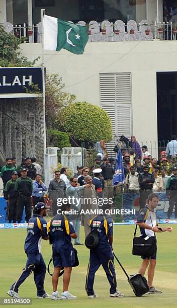 Sri Lankan cricket team members chat before boarding a Pakistani military helicopter before their departure from the playing surface at The National...