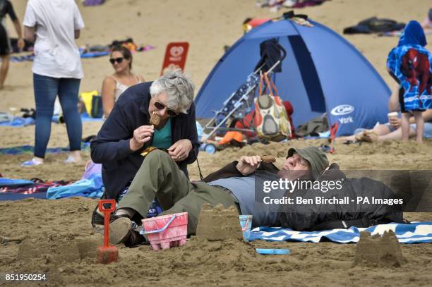 Photo. People relax on Croyde beach, Devon, where the UK National Sandcastle competition is being held to raise money for North Devon Hospice, which...