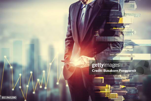 businessman holding smart phone. double exposure photo of city view background, finance strategy concept. - man suit using phone tablet foto e immagini stock