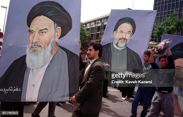 Supporters of president Mohammad Khatami carry a painting of him along with those of Ayatollah Khomeini and Ayatollah Khamenei on the first...