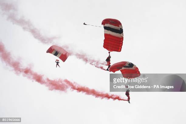 British Army parachute regiment display team Red Devils fly into the main arena to officially open day one of the V Festival at Weston Park in...