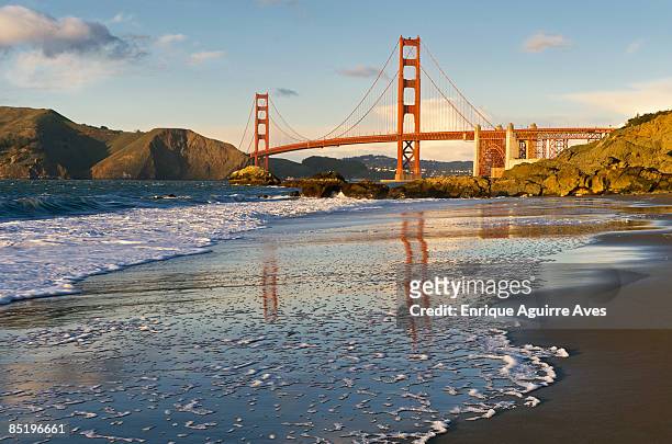 golden gate bridge reflected on wet sand - bahía de san francisco fotografías e imágenes de stock