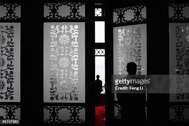 Security officer stands guard at the main entrance of the Great Hall of the People during the opening session of the Chinese People's Political...