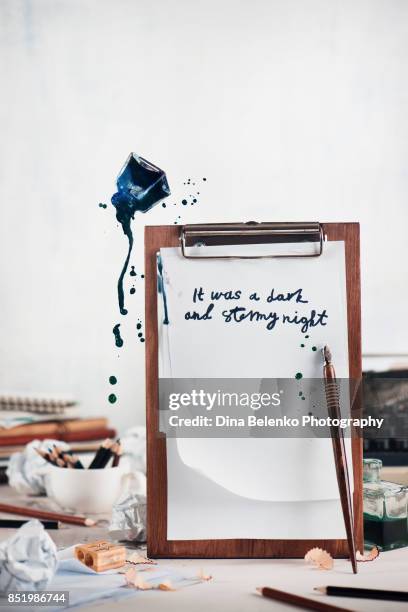 wooden tablet with blank pages and flying inkwell. dynamic still life with spilled ink. creative writing concept. overcoming creative block and searching for new ideas. - blank book on desk stock-fotos und bilder