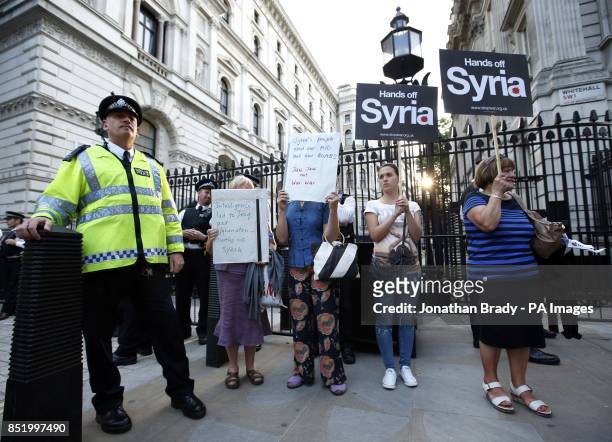Activists hold placards outside Downing Street during an event organised by Stop the War Coalition to protest against potential UK involvement in the...