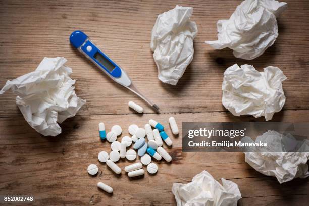 thermometer, medicine, tissue and a cup of tea on wooden background - tissue box stockfoto's en -beelden