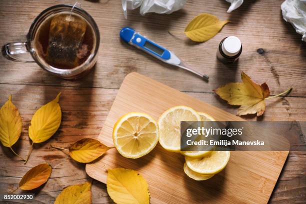 thermometer, medicine, tissue and a cup of tea on wooden background - box of tissues stock pictures, royalty-free photos & images