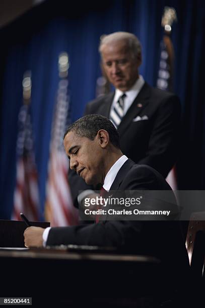 Vice President Joe Biden stands with US President Barack Obama as he signs the American Recovery and Reinvestment Act at the Denver Museum of Nature...
