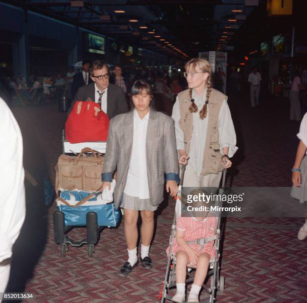 Woody Allen and his partner, actress Mia Farrow, with some of their children at London Heathrow Airport, 8th August 1988, .