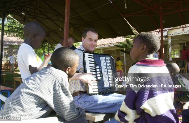 Pilot Simon Wood of Barnet, London, changes his flight instruments for a musical one as he entertains an HIV positive orphan during an Easter party...