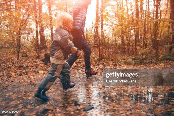 mother and child in the park - russia rain boots imagens e fotografias de stock