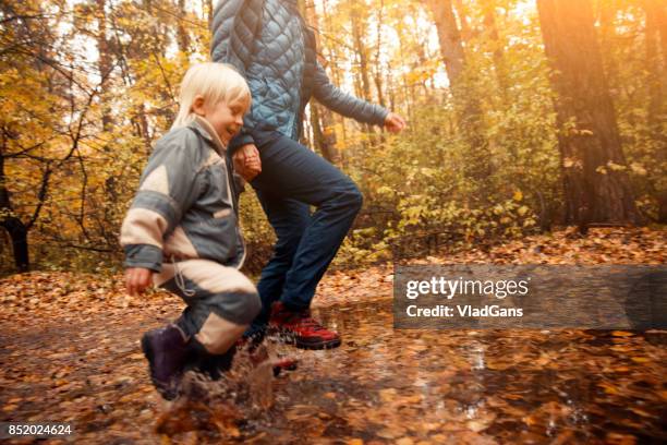 mother and child in the park - russia rain boots imagens e fotografias de stock