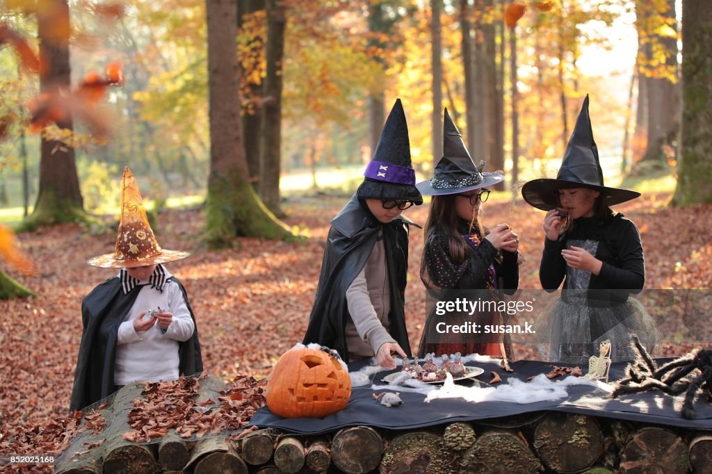 Children having halloween party in the woods.