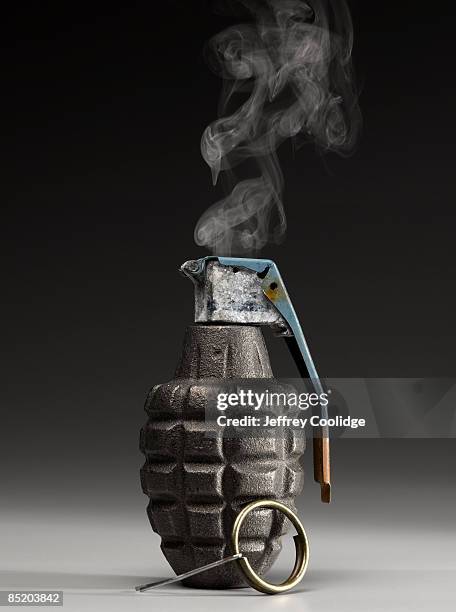 smoking hand grenade with pin pulled - hand grenade stock pictures, royalty-free photos & images