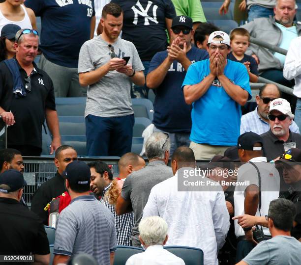 Young girl is being assisted after being hit by a line drive off the bat of Todd Frazier of the New York Yankees as fans around her watch in shock in...