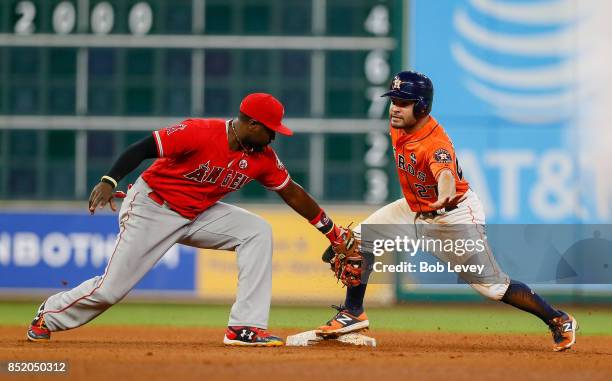 Jose Altuve of the Houston Astros steals second base as in the seventh inning as Brandon Phillips of the Los Angeles Angels of Anaheim is late with...