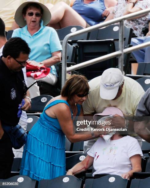 Fan is helped by the medical staff after getting hit in the face by a foul ball off the bat of Kelly Shoppach of the Cleveland Indians during a...