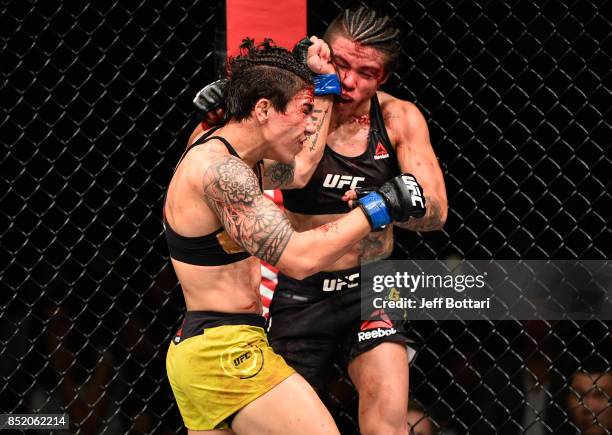 Jessica Andrade of Brazil exchanges punches with Claudia Gadelha of Brazil in their women's strawweight bout during the UFC Fight Night event inside...