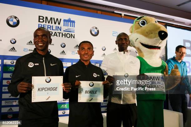 Eliud Kipchoge, Kenenisa Bekele, Wilson Kipsang and mascot Fridolin Flink are pictured from left to right at the press conference. The three leading...