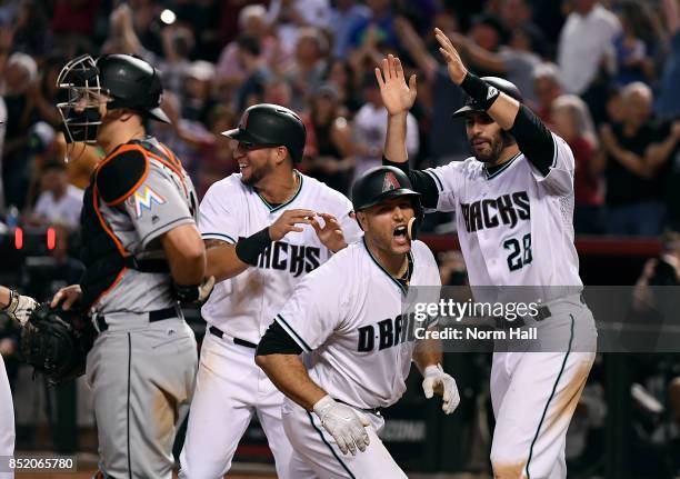 Chris Iannetta of the Arizona Diamondbacks celebrates with teammates JD Martinez and David Peralta after hitting a grand slam home run during the...