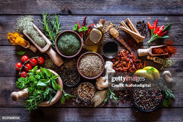 spices and herbs on rustic wood kitchen table - herbs and spices stock pictures, royalty-free photos & images