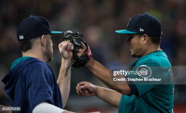 Starting pitcher Erasmo Ramirez of the Seattle Mariners is congratulated by David Phelps of the Seattle Mariners in the dugout after the eighth...