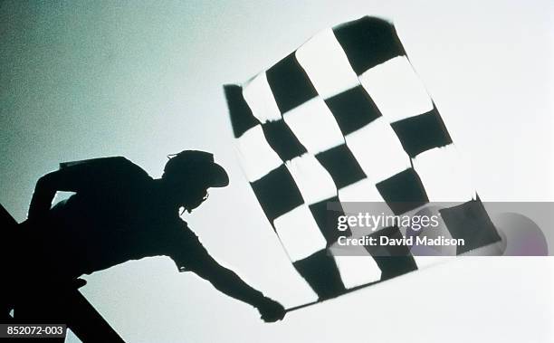 man waving checkered flag at motor race, (b&w) - bandeira de chegada imagens e fotografias de stock