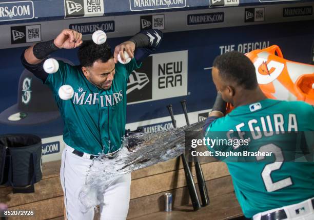 Nelson Cruz of the Seattle Mariners tries avoid a water bath from teammate Jean Segura of the Seattle Mariners after Cruz hit a game-winning two-run...