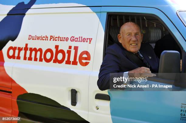 Former Formula One racing driver, Sir Stirling Moss behind the wheel of the Dulwich Picture Gallery's Artmobile, which is covered in art by Royal...